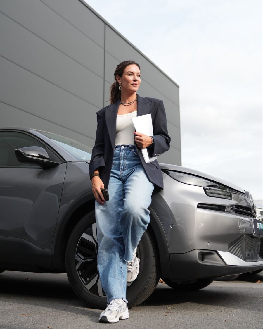 Britt van MobiJobs bij een wagen op de parking van een automotivebedrijf
